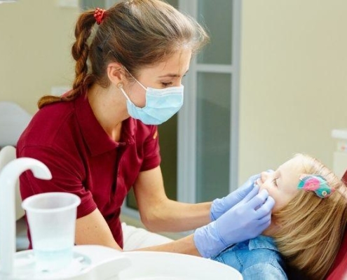 dentist looking into childs mouth